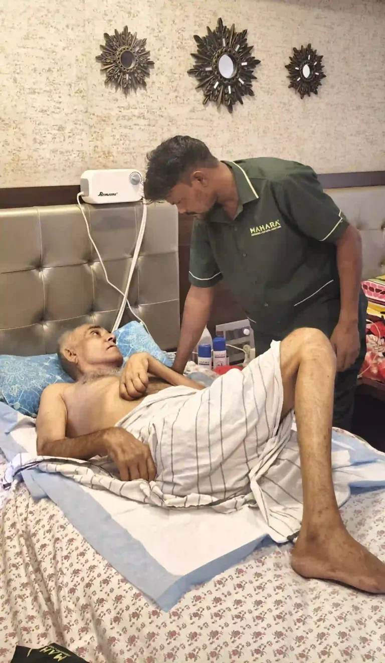 Male Mahara home nurse attending to an elderly bedridden patient on a bed
